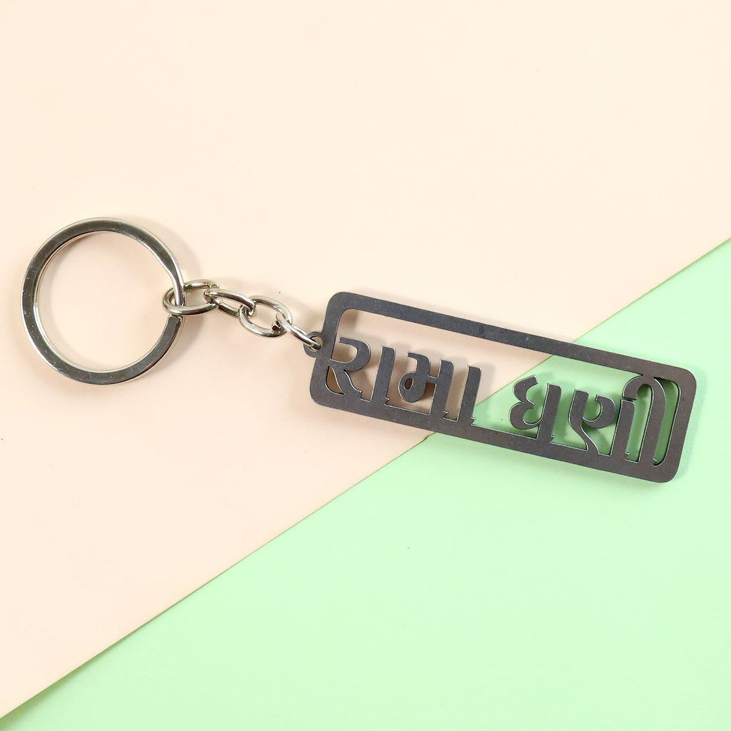 Top view of Gujarati devotional metal keychain with key holding ring