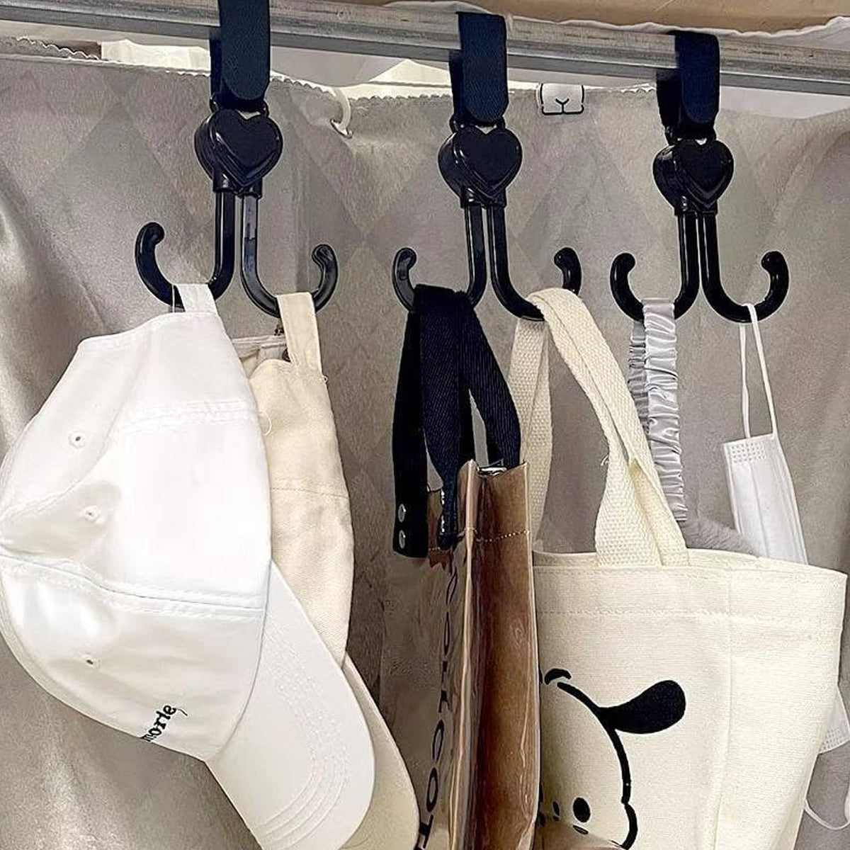 A 360-degree rotating stroller hook securely attached to a baby stroller handle.