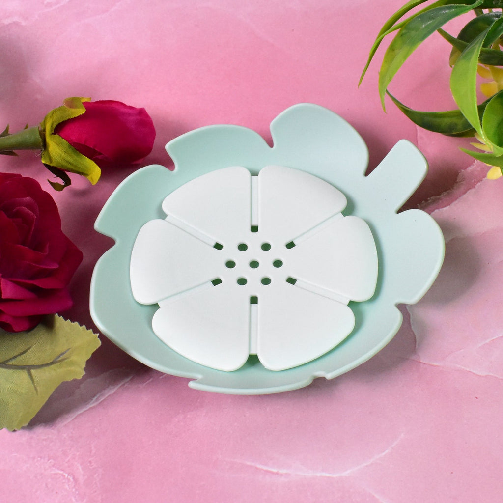 Set of two floral plastic soap dishes, one white and one pink, in a bathroom.