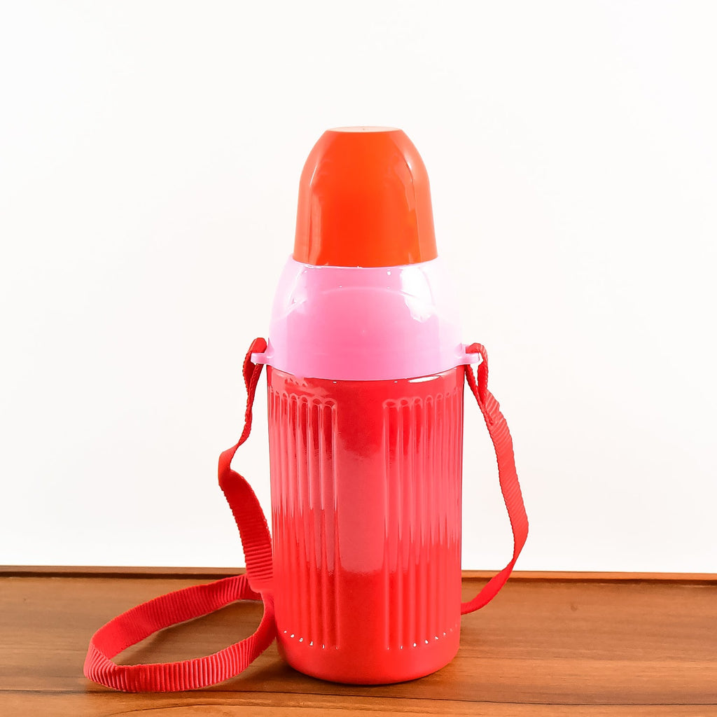 Child happily carrying the water bottle with its adjustable strap.
