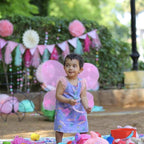 Baby girl wearing multi-color butterfly wings with a matching wand and hairband.