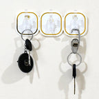 Close-up of a clear plastic transparent adhesive hook with a stainless steel hook.