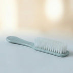 Handheld brush cleaning a shoe sole, demonstrating versatile utility