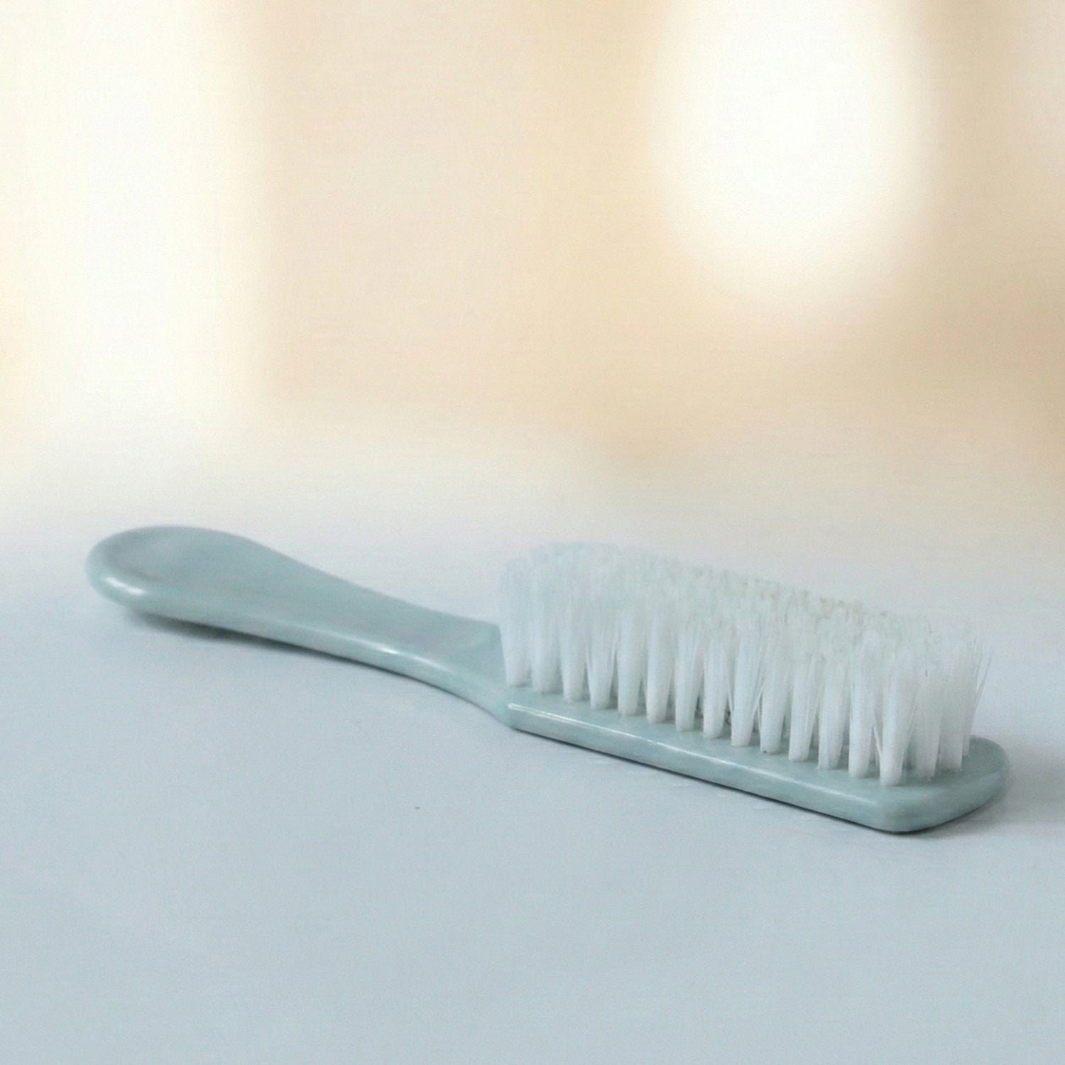 Handheld brush cleaning a shoe sole, demonstrating versatile utility
