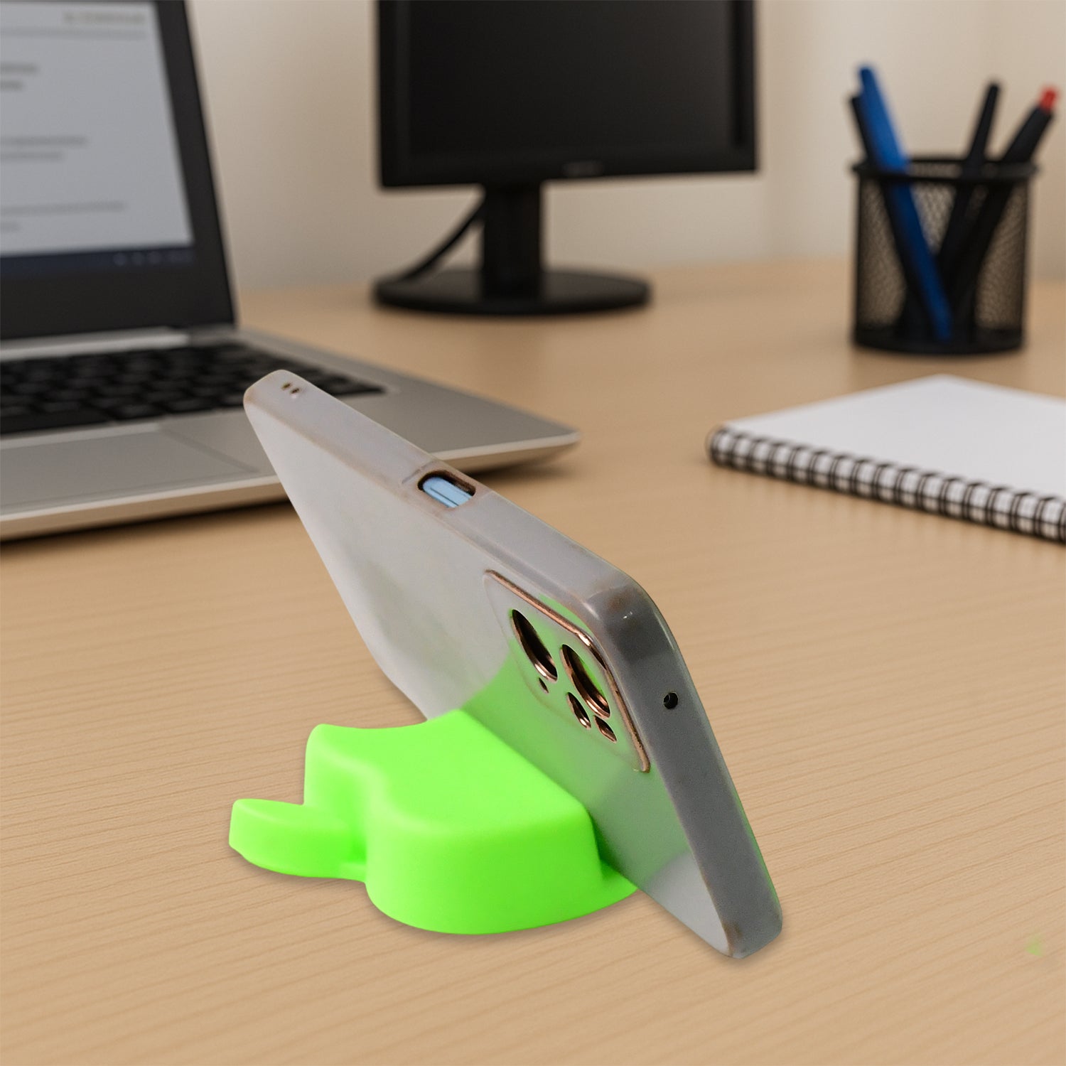 Apple-shaped plastic mobile phone stand set in assorted colors on a desk
