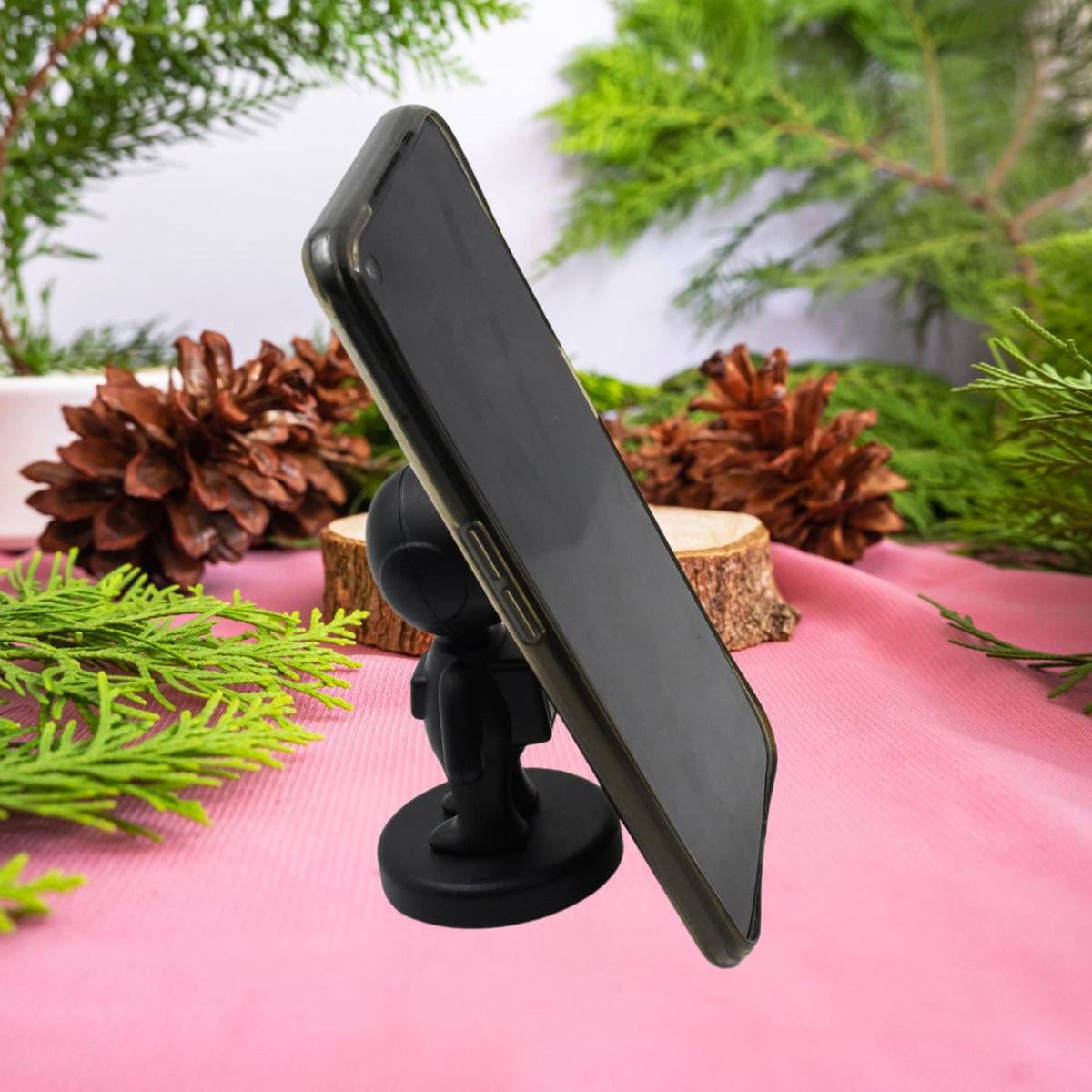Cartoon Astronaut Magnetic Phone Holder securely mounted on a car dashboard for hands-free use.