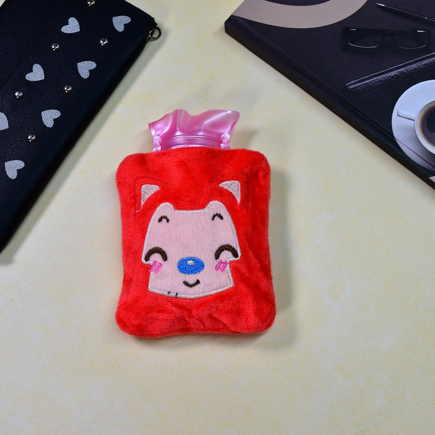 Close-up of pink cat hot water bag, offering relief for menstrual cramps.