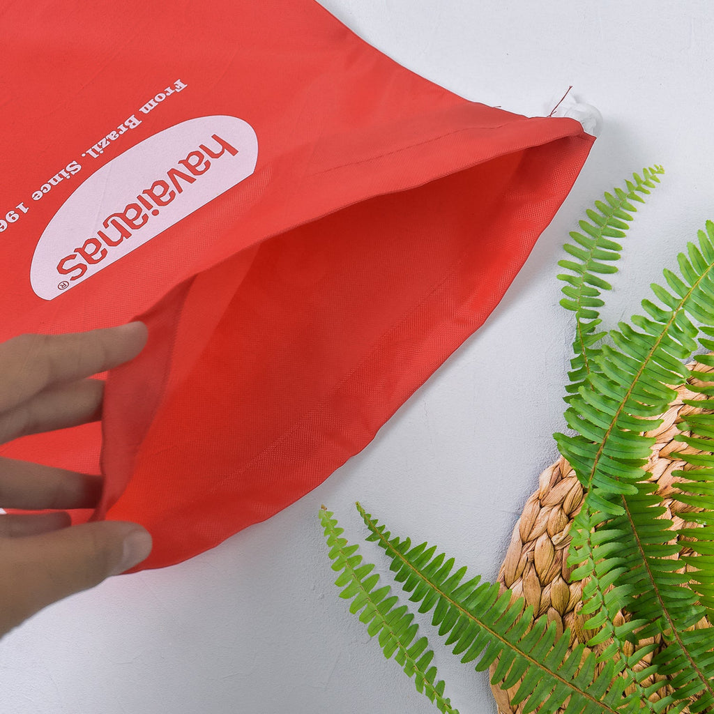 Compact red drawstring bag folded, ideal for space-saving storage.