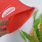 Compact red drawstring bag folded, ideal for space-saving storage.