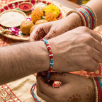 Cotton red thread rakhi with elegant beadwork