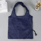 A compact reusable grocery bag expertly folded into its small pouch for easy storage.