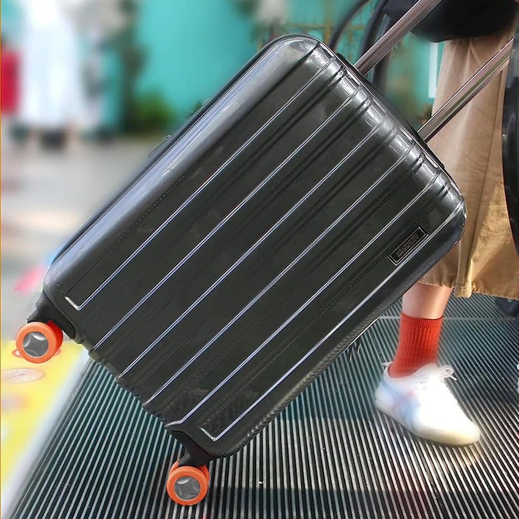 A hand easily installing a vibrant blue silicone luggage wheel cover onto a suitcase wheel.