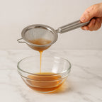 Kitchen strainer filtering liquids during cooking process