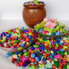 Vibrant decorative pebbles used as vase fillers in a clear glass container.