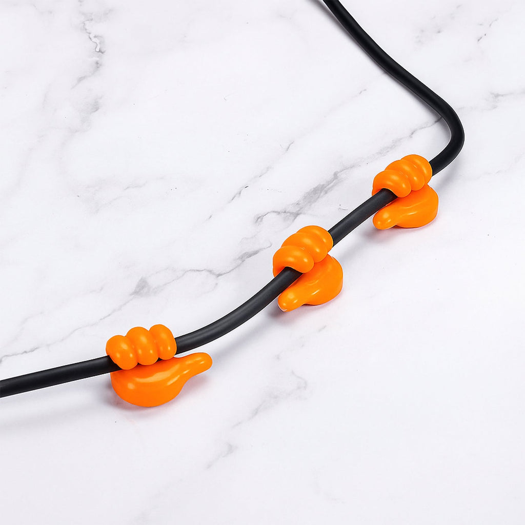 Orange hand clip silicone hanger mounted on wall holding keys