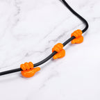 Orange hand clip silicone hanger mounted on wall holding keys
