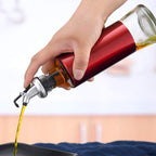 Oil dispenser bottle made of glass with protective plastic covering and golden spout