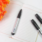 Four black markers displayed on an office desk alongside other stationery items.