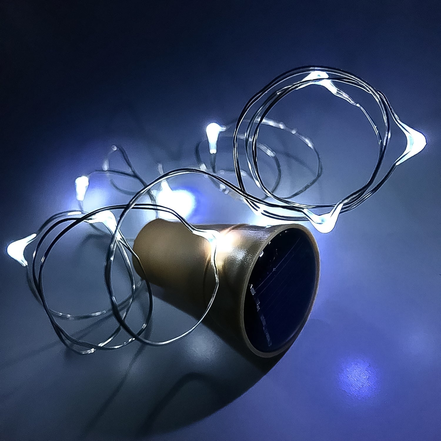 A set of multi-LED copper wire fairy lights emerging from a wine bottle cork.