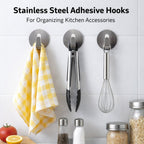 Multiple self-adhesive wall hooks holding various items in an organized display.