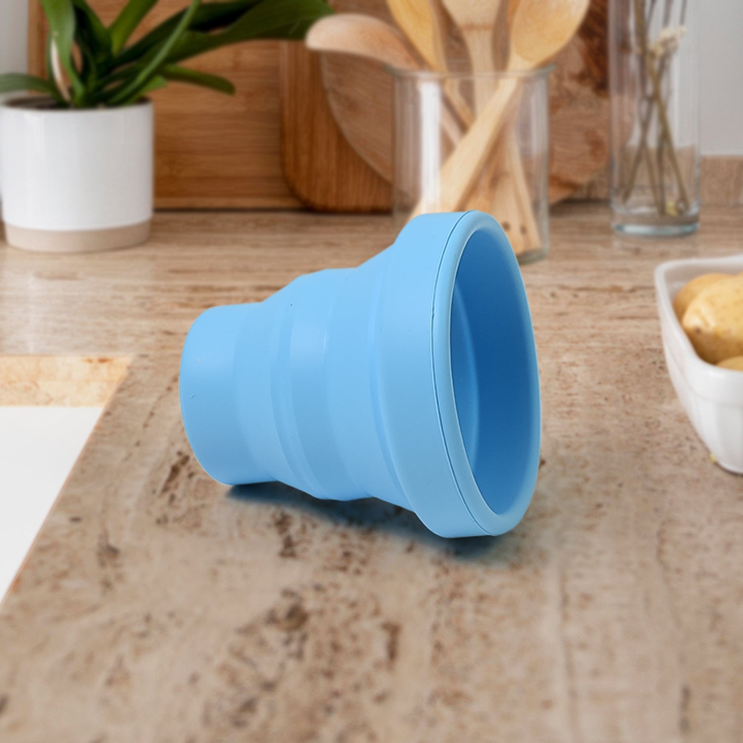 Flexible silicone travel mug in purple, held by hand, highlighting its ergonomic design.
