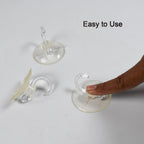 Transparent suction cup hooks holding kitchen utensils on a smooth surface.