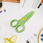 Plastic safety scissors placed on a craft table for toddlers