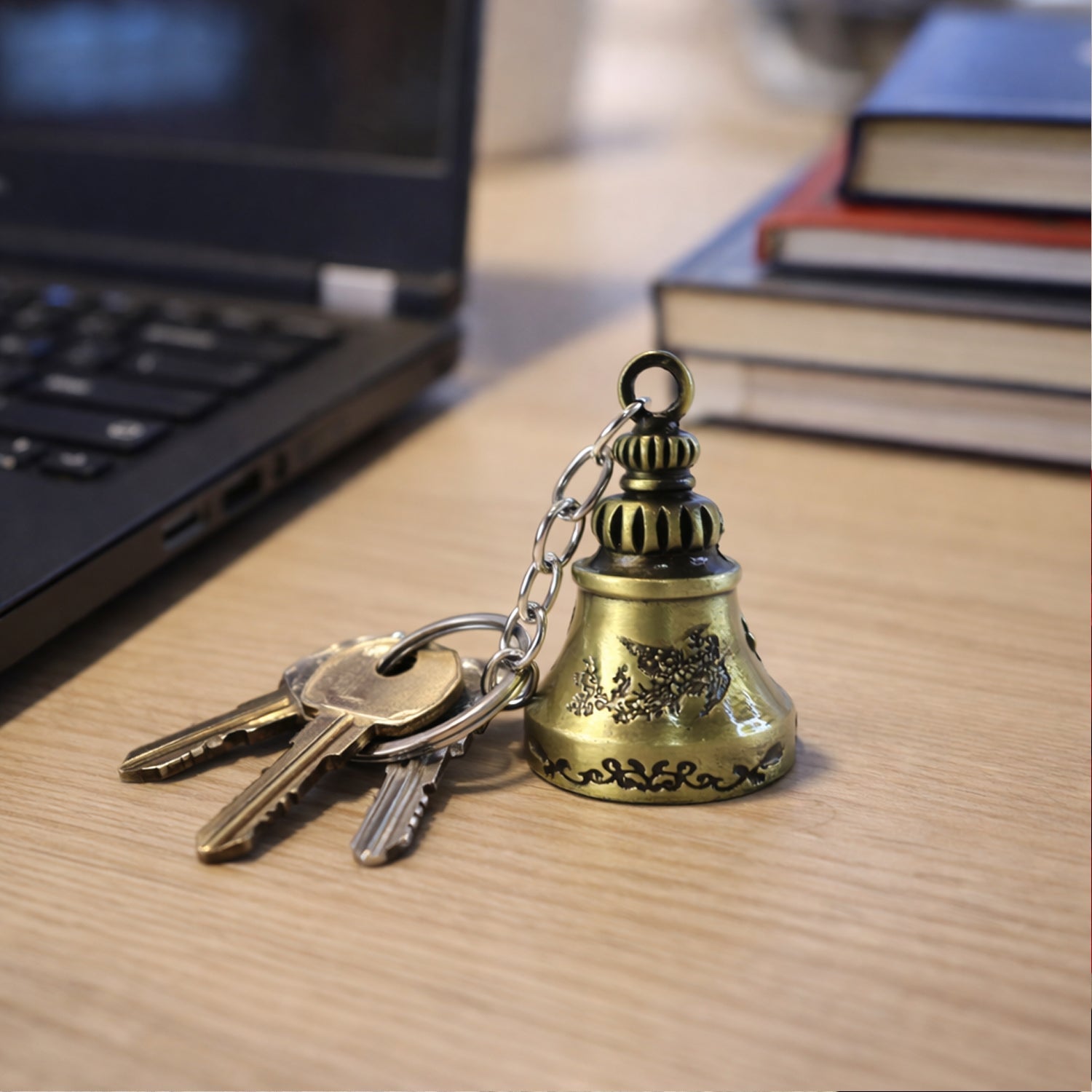 Detailed view of metal temple bell keychain hanging with spiritual design