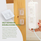 Transparent self-adhesive wall hook displayed on a smooth tile surface.