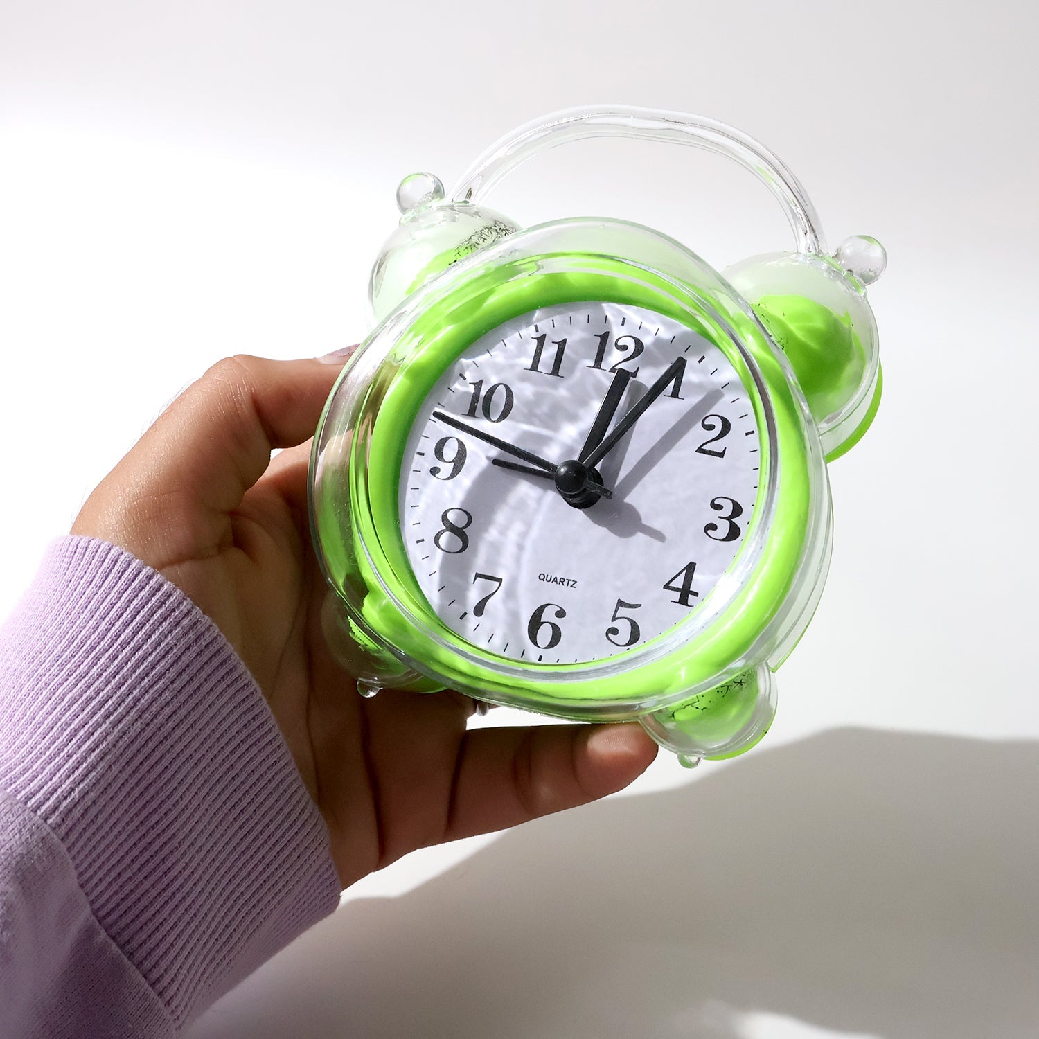 Side view of bright green transparent quartz analog alarm clock