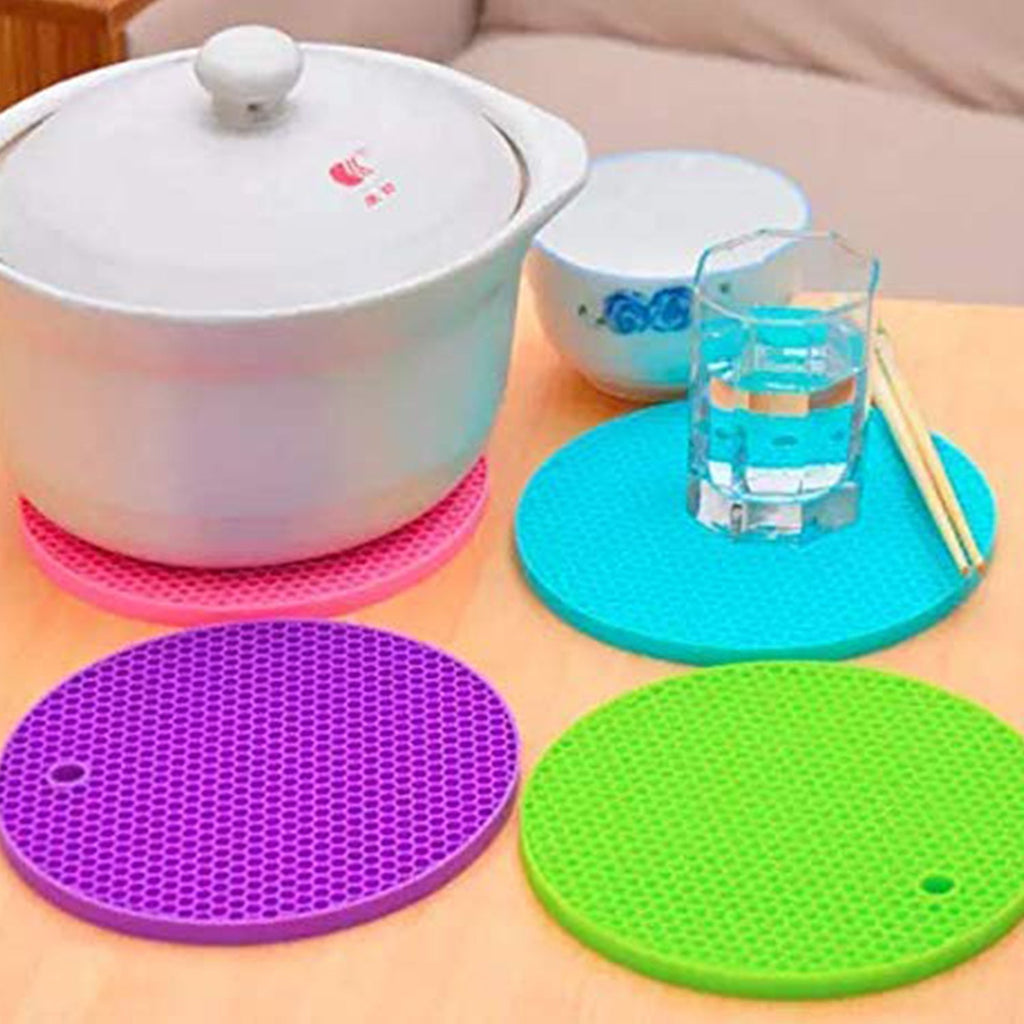 Close-up of a red silicone hot pot mat, highlighting its textured design for better grip.