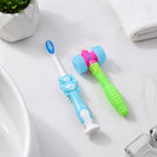 Happy child brushing teeth with playful hammer toy toothbrush
