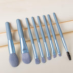 A person holding a blending brush from the 8-piece mini makeup brush set, demonstrating its size.