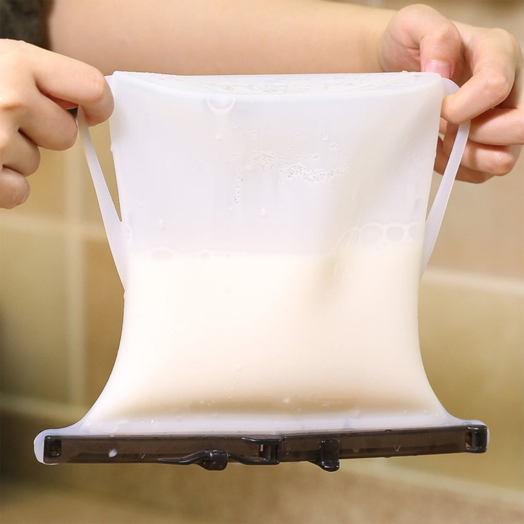 A hand holding a filled Reusable Silicone Food Storage Bag, ready for transport or storage.