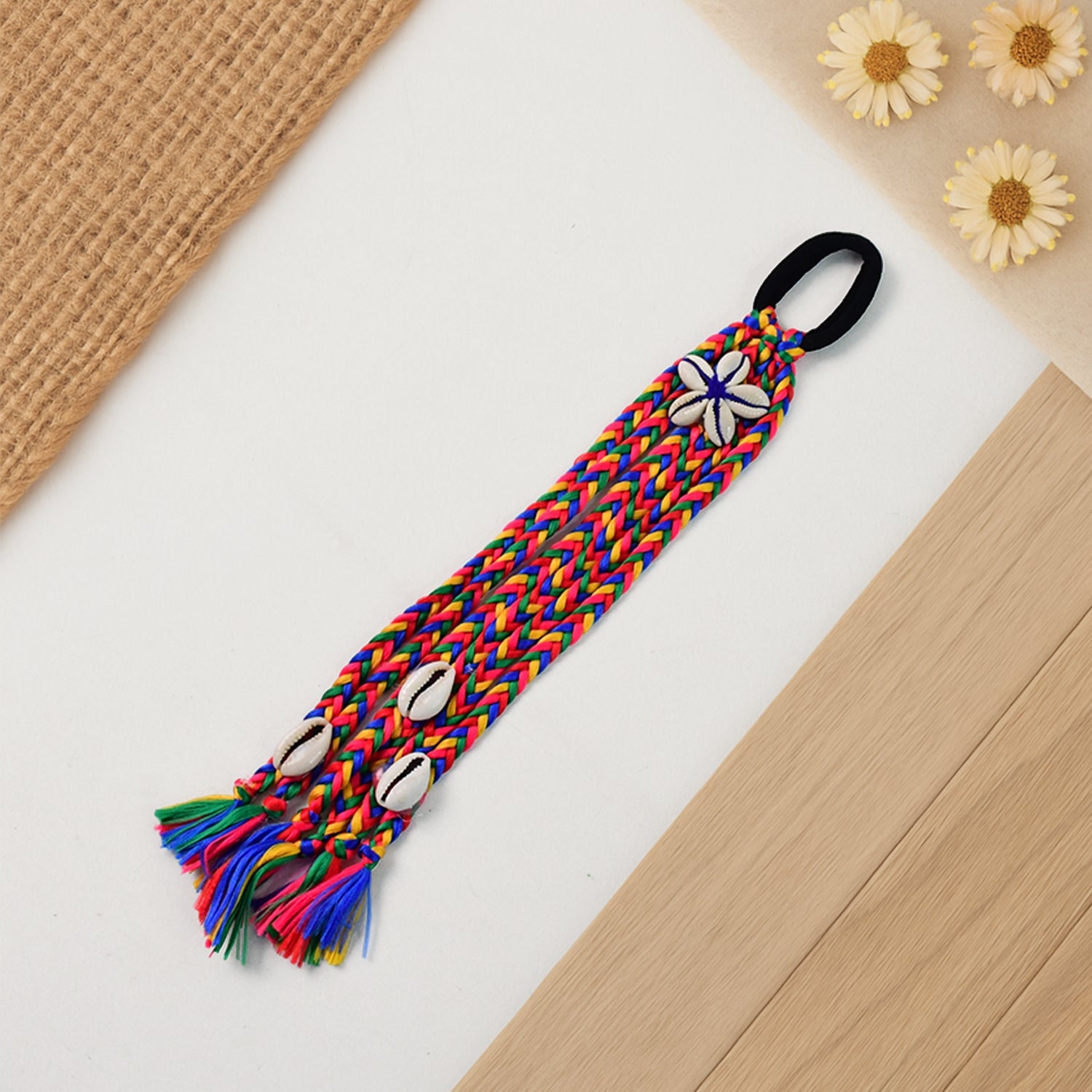 Close-up of multicolor braided hair accessory showing braided texture and shells