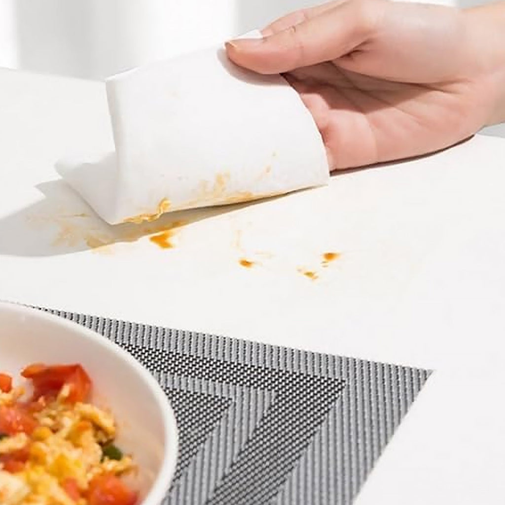 A used kitchen cleaning wipe effectively removing stubborn oil stains from a counter.