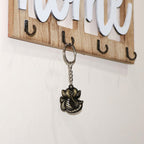 Hand holding Ganesh Face Antique Black Metal Keychain, highlighting portability