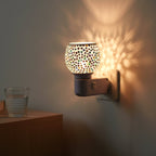 Close-up of intricate star pattern mosaic glass shade on night lamp