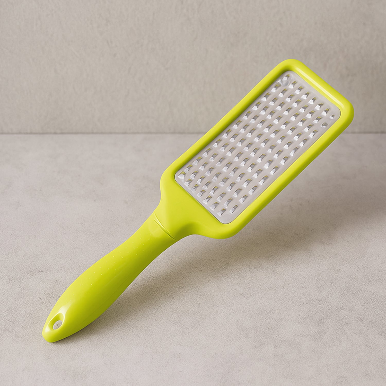 A CookAura Stainless Steel Cheese Grater with a black handle, featuring a sharp grating surface.
