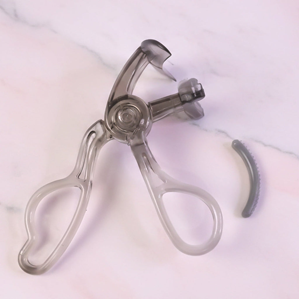 Transparent eyelash curler viewed from side angle showing smooth press