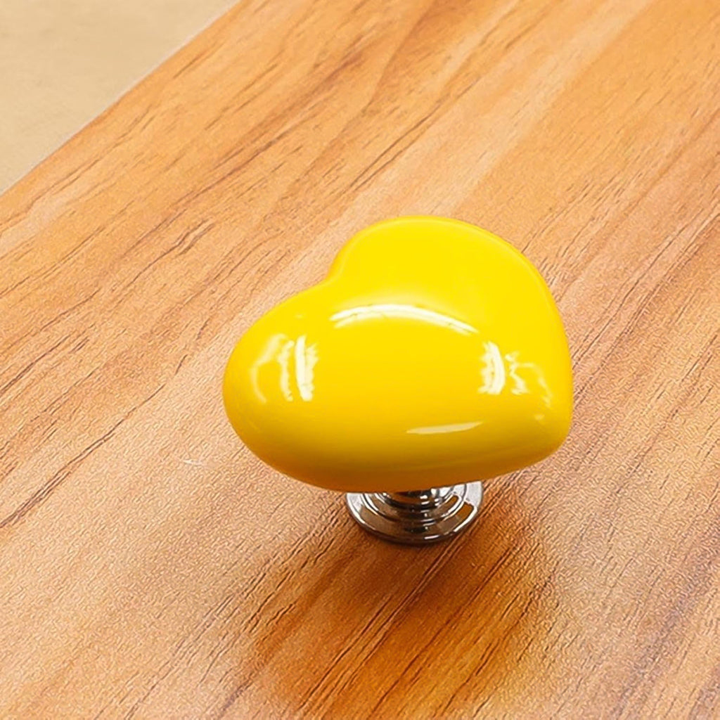 Bright yellow heart-shaped knob, adding a cheerful accent to furniture.