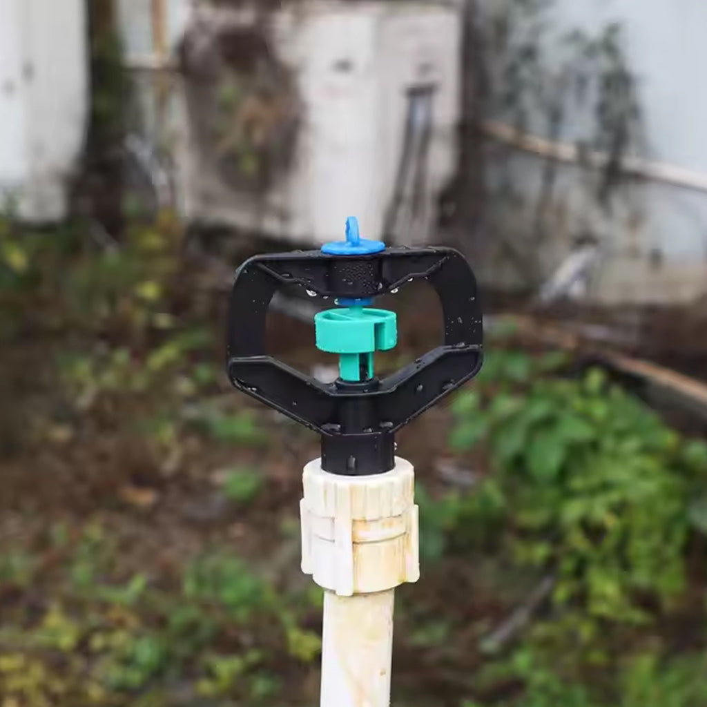Rotating plastic spray nozzle distributing water evenly across plants.