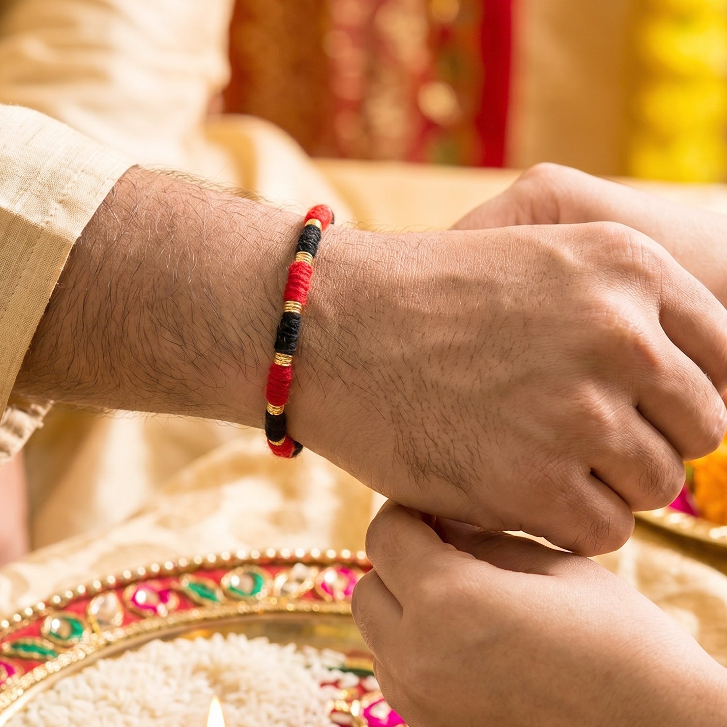 Closeup of handmade red and black Rakhi with golden beads