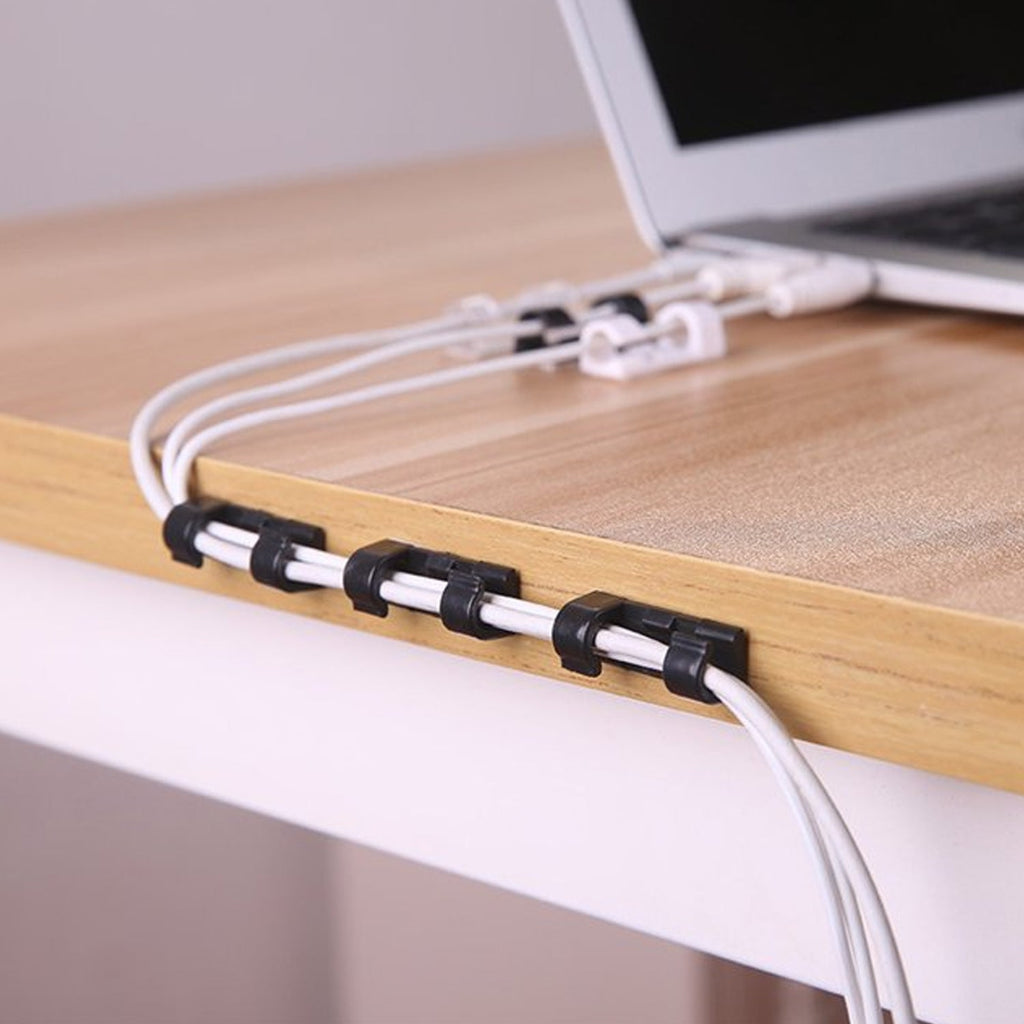 Close-up view of a plastic cable clip, highlighting its compact design and strong adhesive.