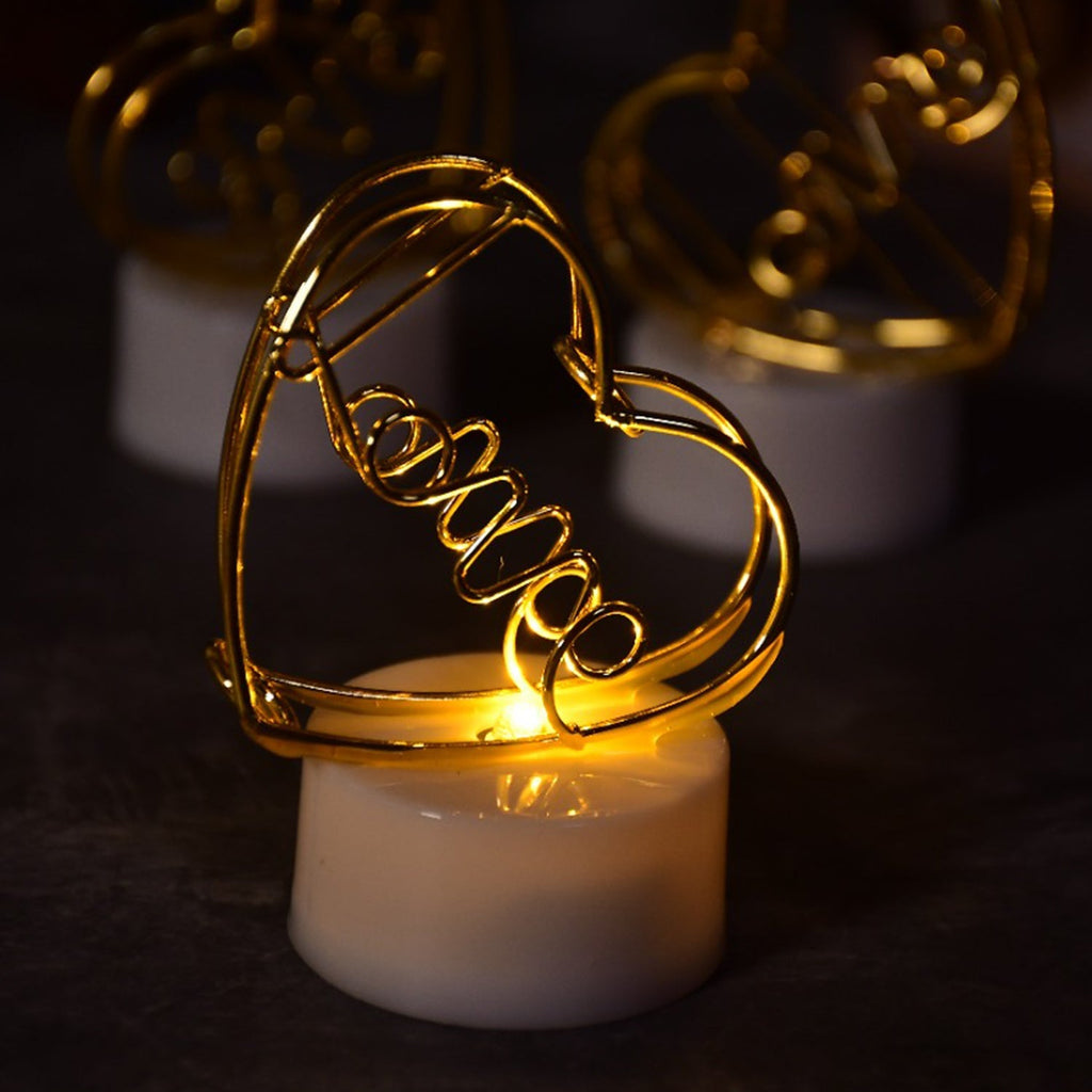 A close-up view of three glowing multicolor flameless heart candles, showcasing their realistic flickering effect.