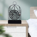Decorative mosquito coil holder used outdoors on a patio table at dusk.