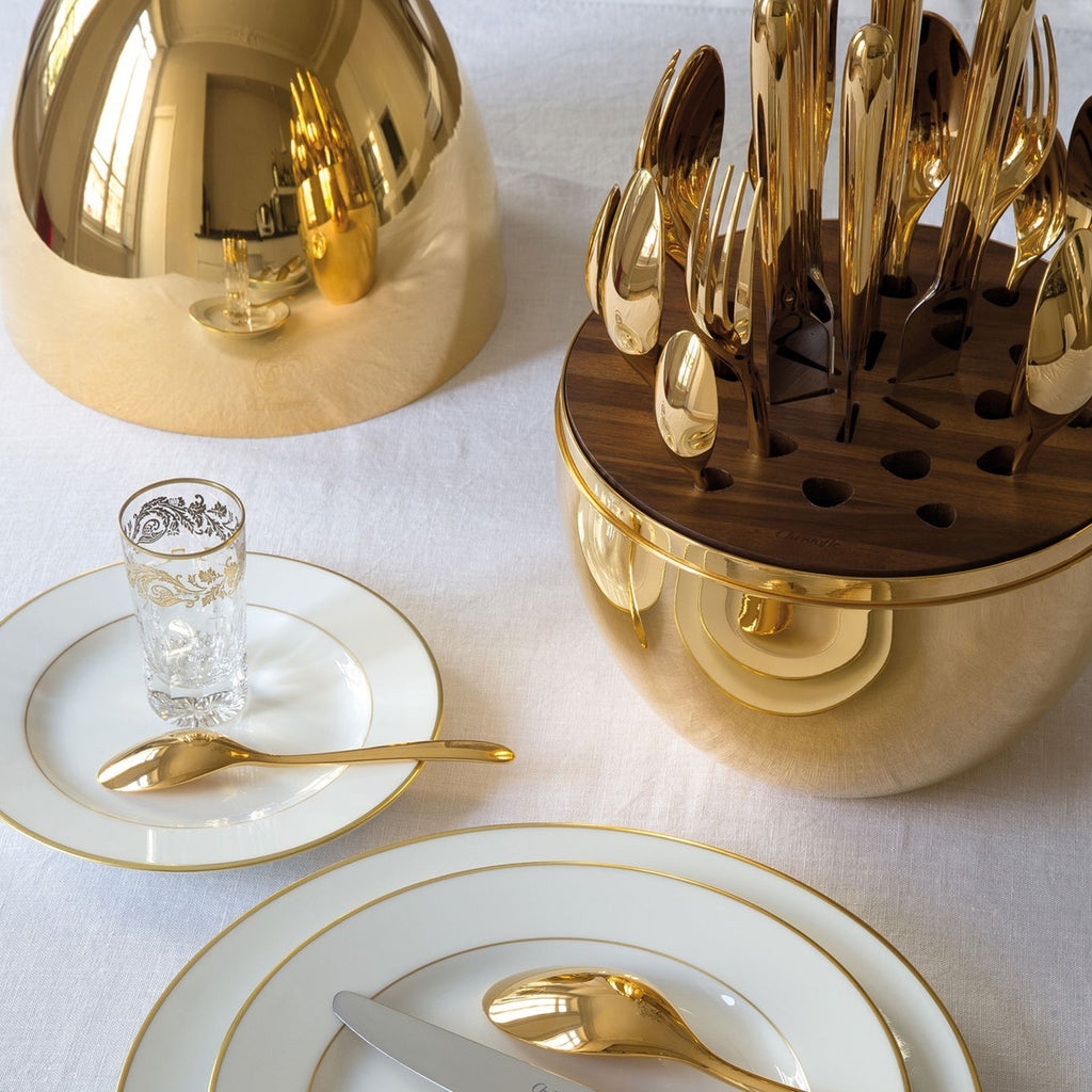 Elegant 24-piece golden cutlery set with an oval stand on a dining table.