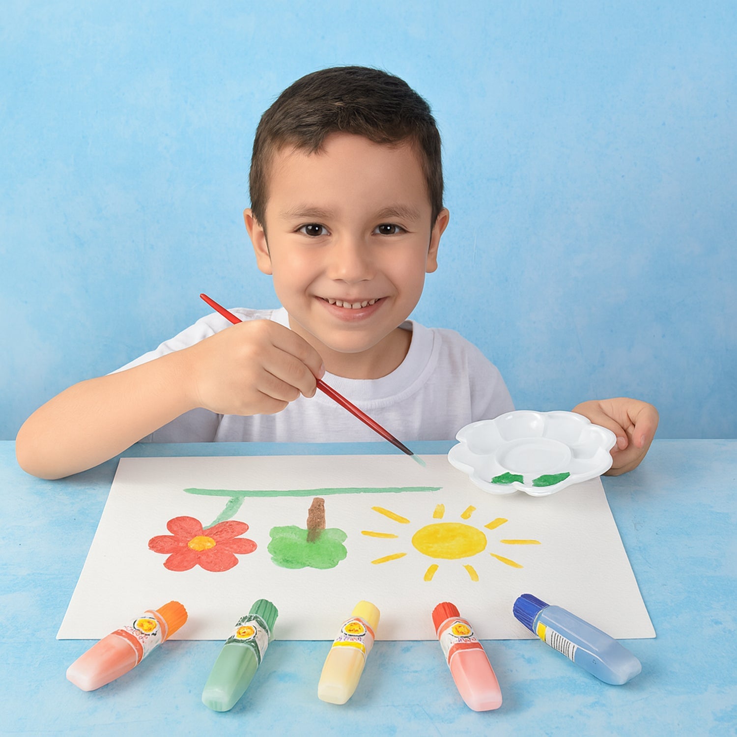 Watercolor paint set with assorted colors arranged with mixing palette and brushes