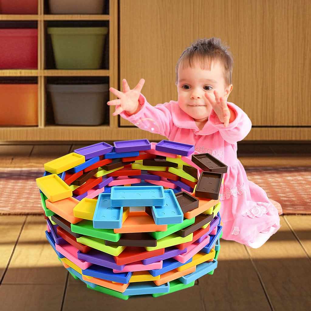Kids carefully stacking colorful wooden domino blocks into creative structures.