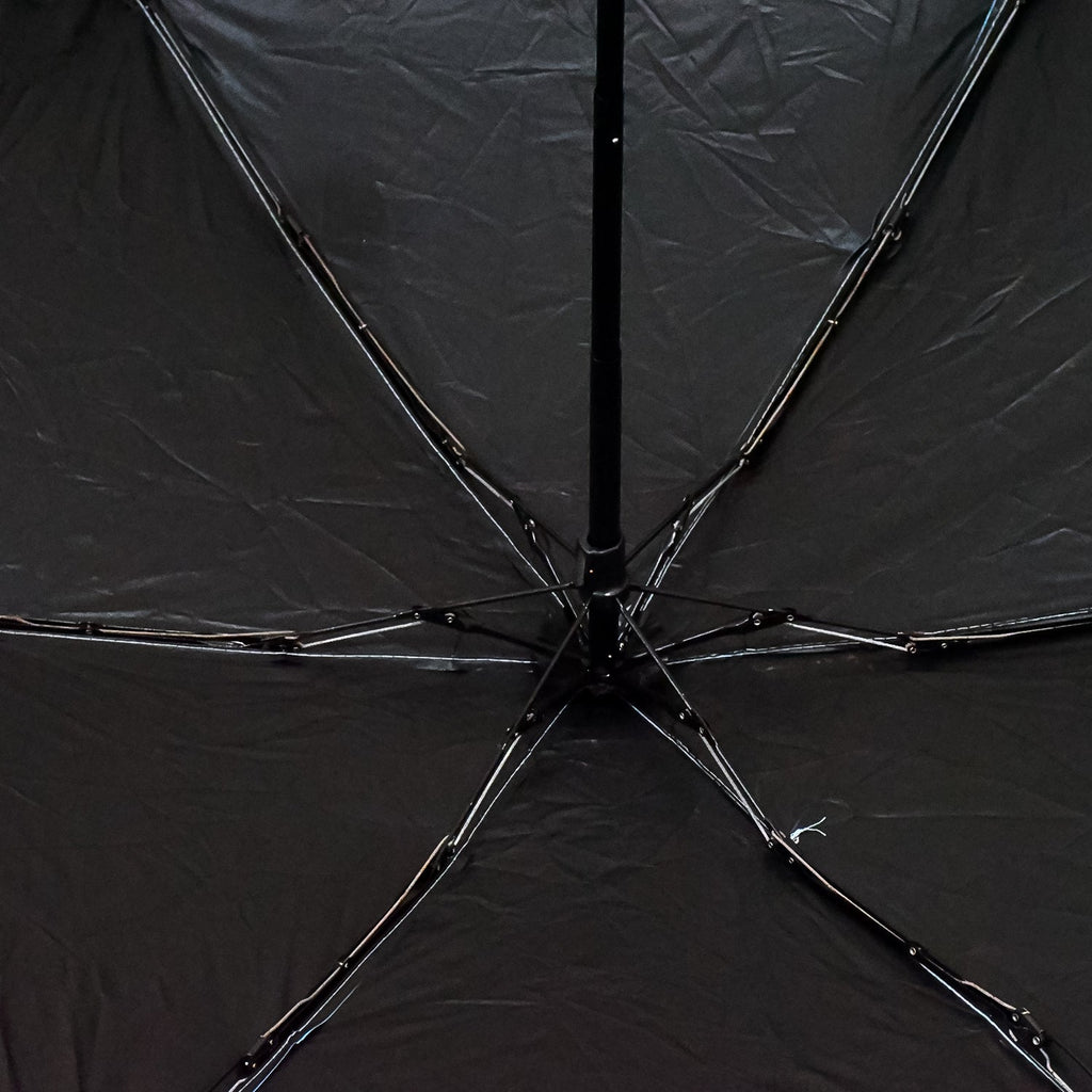 A DrizzlePro portable umbrella closed and ready to be stored, highlighting its compact design.